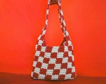 May include: A red and white checkered crocheted tote bag with a single strap.