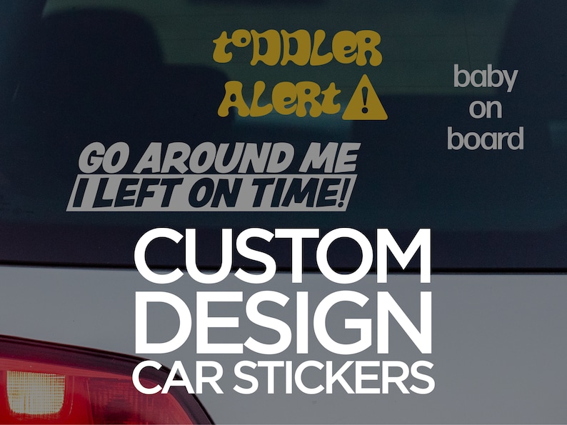 May include: A white car with a black rear window. The window has a yellow and black sticker that says "Toddler Alert!" and a gray sticker that says "Go Around Me I Left On Time!" There is also a gray sticker that says "baby on board". The car has a white sticker that says "CUSTOM DESIGN CAR STICKERS".