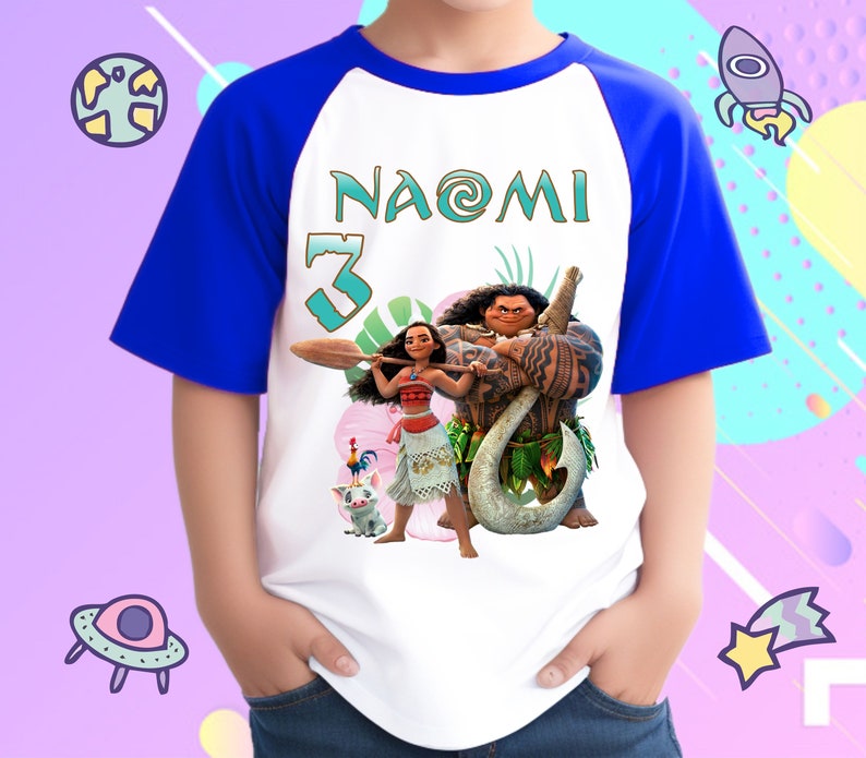 K&ouml;nnte beinhalten: Ein wei&szlig;es T-Shirt mit blauen Raglan&auml;rmeln, das ein Motiv von Moana und Maui zeigt. Das Shirt tr&auml;gt den Namen "NAOMI" und die Nummer "3" aufgedruckt.