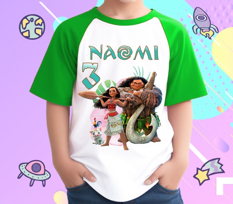 K&ouml;nnte beinhalten: Wei&szlig;es und gr&uuml;nes Raglan-T-Shirt mit einem Moana- und Maui-Motiv. Das Shirt hat den Namen "Naomi" und die Nummer "3" auf der Vorderseite.