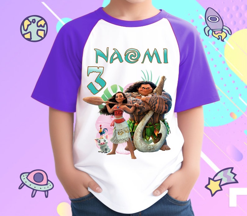 K&ouml;nnte beinhalten: Wei&szlig;es und violettes Baseball-T-Shirt mit einem Moana- und Maui-Motiv. Das Shirt tr&auml;gt den Namen "NAOMI" und die Nummer "3" aufgedruckt.