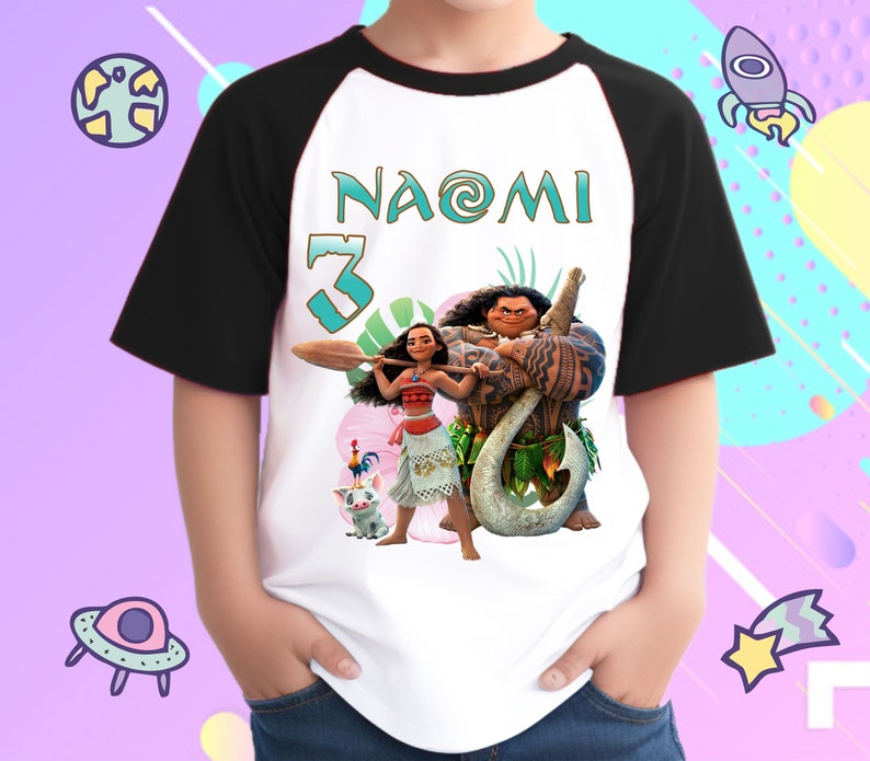K&ouml;nnte beinhalten: Ein wei&szlig;es und schwarzes Baseball-T-Shirt mit einer bunten Grafik von Moana und Maui aus dem Disney-Film Moana. Das Shirt tr&auml;gt den Namen "Naomi" und die Nummer "3" auf der Vorderseite.