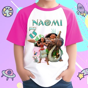 K&ouml;nnte beinhalten: Ein wei&szlig;es und pinkfarbenes Raglan-T-Shirt mit einem Moana- und Maui-Motiv. Das Shirt tr&auml;gt den Namen "NAOMI" und die Nummer "3" auf der Vorderseite.