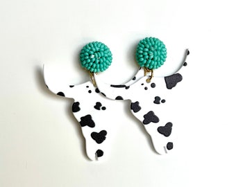 Brincos turquesa com estampa de vaca, moldura em formato de vaca.
