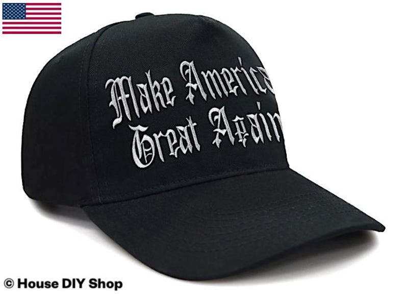 Peut inclure: Casquette de baseball noire avec l'inscription blanche brod&eacute;e "Make America Great Again" en lettres gothiques. La casquette a une visi&egrave;re incurv&eacute;e et une couronne structur&eacute;e. Le drapeau am&eacute;ricain est en haut &agrave; gauche.