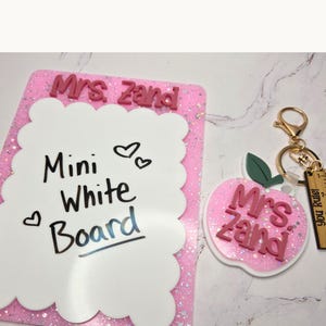 Scalloped white board personalized with teacher name and layered acrylic details. Small dry erase teacher desk notepad used for classroom reminders and daily notes. Cute teacher desk accessory and thoughtful teacher appreciation gift from students or parents for new teacher classroom organization. Mini whiteboard pairs perfectly with matching teacher keychain.