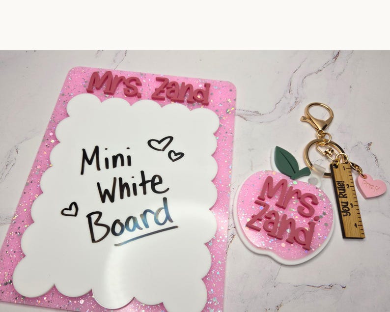 Scalloped white board personalized with teacher name and layered acrylic details. Small dry erase teacher desk notepad used for classroom reminders and daily notes. Cute teacher desk accessory and thoughtful teacher appreciation gift from students or parents for new teacher classroom organization. Mini whiteboard pairs perfectly with matching teacher keychain.