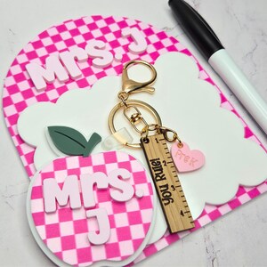 Teacher dry erase note board with apple keychain and personalized name in layered acrylic. Small reusable classroom whiteboard used as a teacher desk notepad for reminders and daily classroom tasks. Thoughtful teacher appreciation gift, back to school classroom gift, and personalized teacher desk decor.