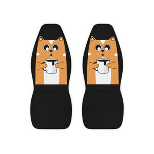May include: Two black car seat covers with a cartoon orange cat holding a cup of coffee on each cover.