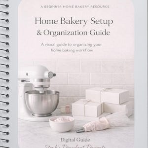 Op de afbeelding: Een digitaal gids met spiraalbinding getiteld "Home Bakery Setup & Organization Guide". De omslag toont een witte keukenmachine, een kom met roze glazuur, witte dozen en een spuitzak. Tekst bevat "A Beginner Home Bakery Resource."