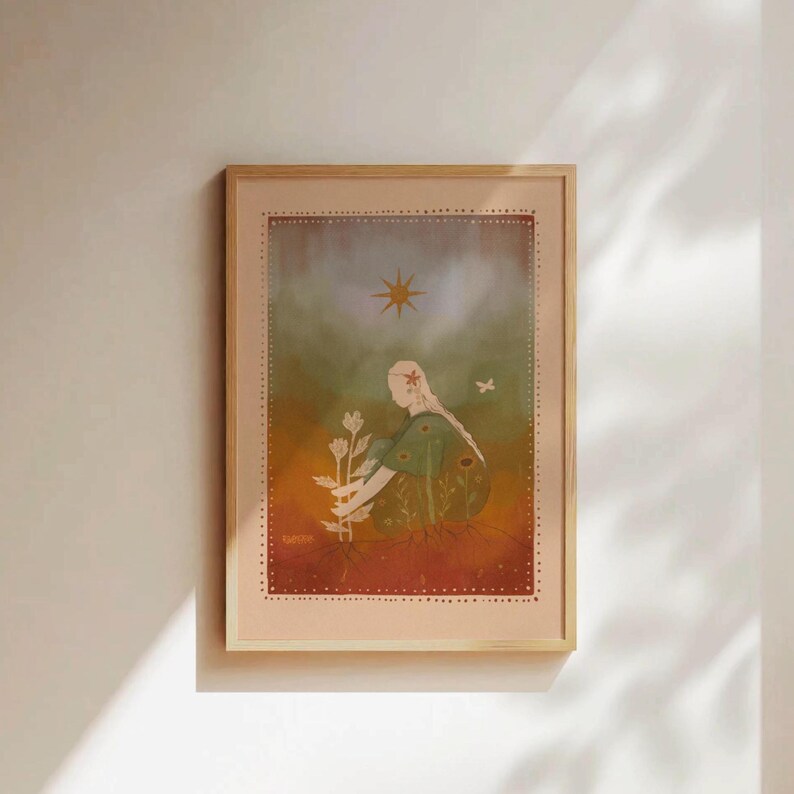 May include: Framed art print featuring a seated figure tending to flowers. The artwork has a warm color palette with a sun and butterfly. The print is in a light wood frame, suitable for home decor.