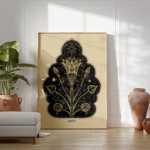 May include: A gold and black print of a stylized flower with a sun and stars on a beige background. The print is framed and hanging on a white wall.
