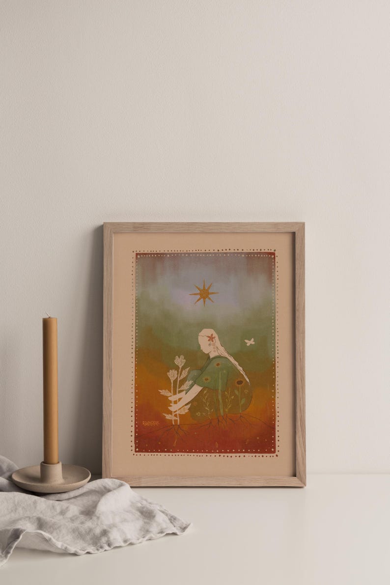 May include: Framed art print featuring an illustration of a person tending to a plant. The artwork has a warm color palette with a figure in a green dress, a star, and a butterfly. The print is in a wooden frame.