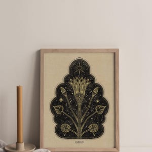 May include: A framed print with a black and gold design of a stylized flower with a sun and stars. The print has the word "remarkable" at the bottom.