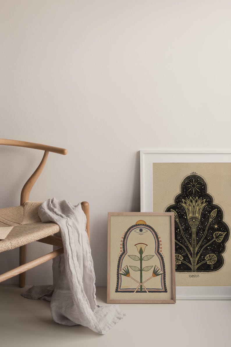 May include: Two framed illustrations with a beige background. The illustration on the left features a stylized flower with a third eye and a geometric archway. The illustration on the right features a stylized flower with a star and a crescent moon.