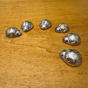 Sei segnaposti argentati a forma di coccinella con occhi blu. Six espaces réservés ou porte-cartes coccinelle aux yeux bleus vintage