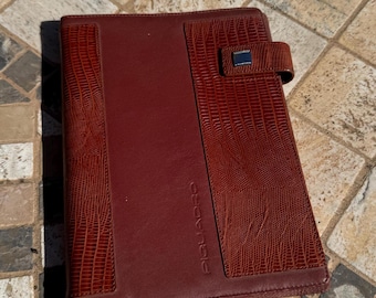 Pre-loved agenda Italiana Piquadro di pelle marrone con inserti in pelle decorata custodia esterna.