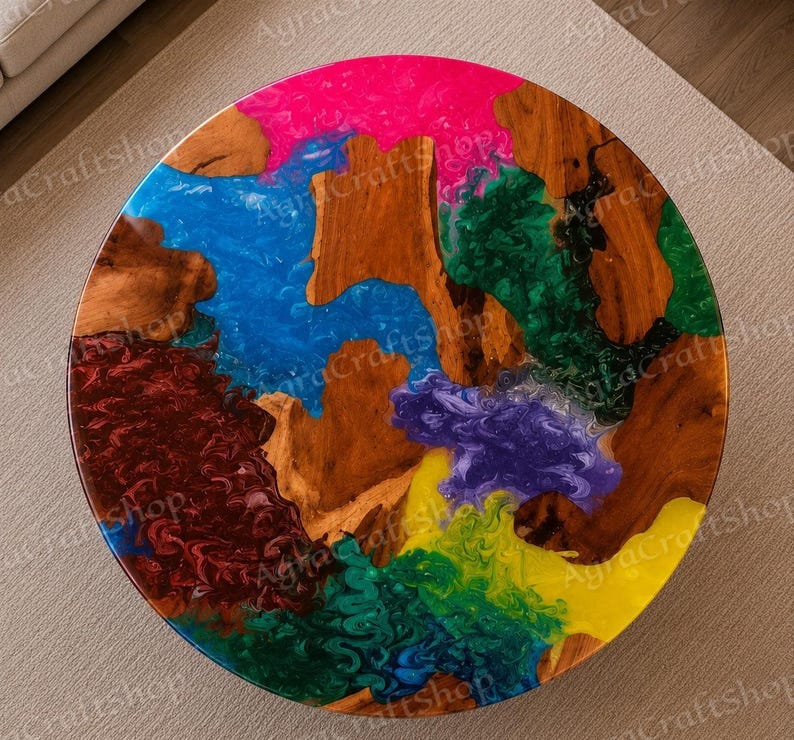 Peut inclure: Une table ronde pr&eacute;sentant une surface en bois naturel int&eacute;gr&eacute;e avec de la r&eacute;sine &eacute;poxy multicolore vive dans des tons rose vif, bleu, vert fonc&eacute;, rouge fonc&eacute;, violet et jaune, cr&eacute;ant un effet marbr&eacute; tourbillonnant sur le dessus.