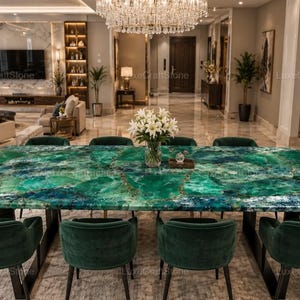 May include: A rectangular dining table featuring a polished green malachite-style stone top with natural veining patterns, supported by a dark metal base, accompanied by eight matching dark green velvet upholstered chairs with curved backrests.