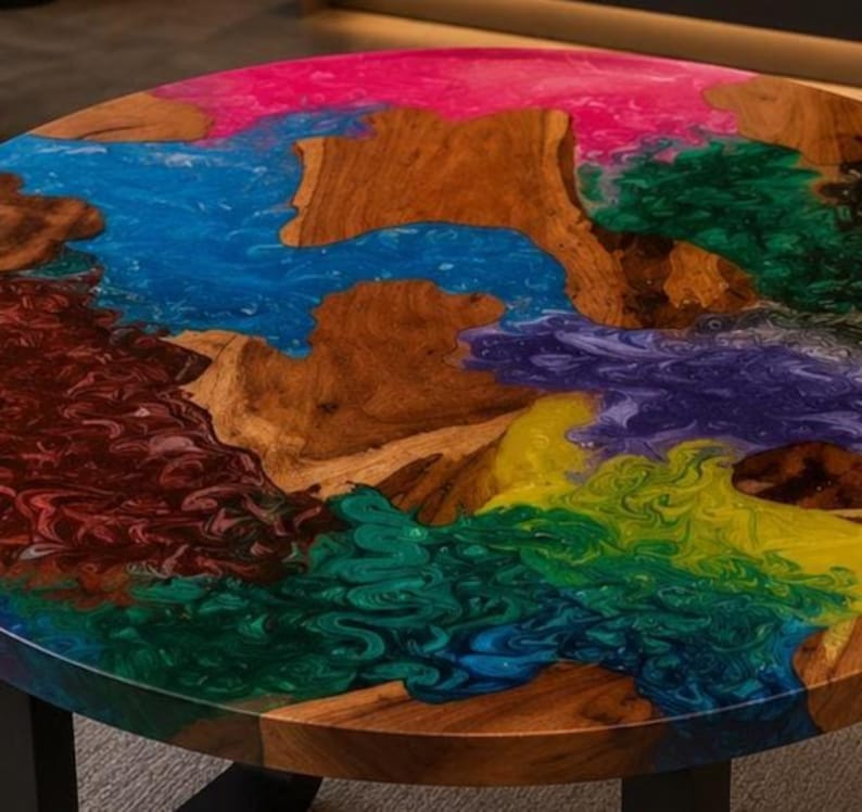 Peut inclure: Une table ronde compos&eacute;e d'une tranche de bois naturel aux bords irr&eacute;guliers int&eacute;gr&eacute;e dans une surface en r&eacute;sine &eacute;poxy multicolore. La r&eacute;sine pr&eacute;sente des motifs tourbillonnants de pigments rose vif, bleu, vert fonc&eacute;, violet, jaune et rouge.