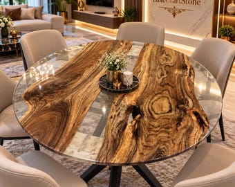 May include: A round dining table featuring two large, natural-edged wood slabs separated by a clear glass center section. The table has a black metal base and is surrounded by six beige upholstered chairs. A small black tray holds a vase and candle.