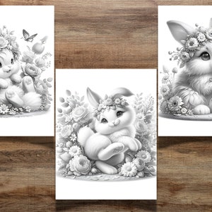 K&ouml;nnte beinhalten: Drei Schwarzwei&szlig;illustrationen von Kaninchen, die Blumenkr&auml;nze tragen. Jedes Kaninchen ist von Blumen und Gr&uuml;n umgeben. Das erste Kaninchen sitzt mit gekreuzten Pfoten. Das zweite Kaninchen sitzt mit den Pfoten unter dem Kinn. Das dritte Kaninchen h&auml;lt eine Blume in seinen Pfoten.