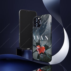 May include: A smartphone case with a dark, abstract design featuring the name "IVAN" in white text. The case has a broken glass effect with a red heart graphic. A second phone is visible in the background.