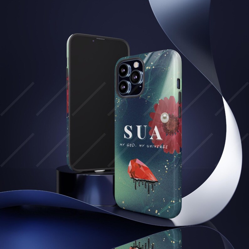 May include: A smartphone and a phone case with a floral design. The case has a red flower with a pearl, the word "SUA", and the text "MY GOD, MY UNIVERSE". The case also features a red gem and a dark blue and green background.