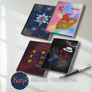 May include: Four personalized notebooks with unique designs. One features a snowflake design, another a fan and butterfly, a third with stylized eyes, and the last with a hat and floral elements. Each notebook has a name printed on it. A pen rests on the surface.