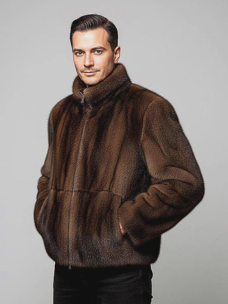 May include: A brown fur jacket with a high collar and a zip fastening. The jacket has a plush texture and a dark brown colour. The model is wearing the jacket with their hands in the pockets.