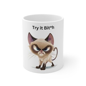May include: White ceramic mug with a cartoon image of a grumpy cat and the text "Try it Bit*h".