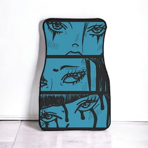 May include: A blue and black car floor mat with a graphic design of three anime-style eyes with black eyeliner and eyelashes.