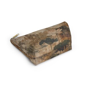 May include: A rectangular cosmetic bag with a gold zipper. The bag features a vintage-style print of a lotus flower, leaves, and an Asian-inspired landscape in shades of brown, beige, and green.