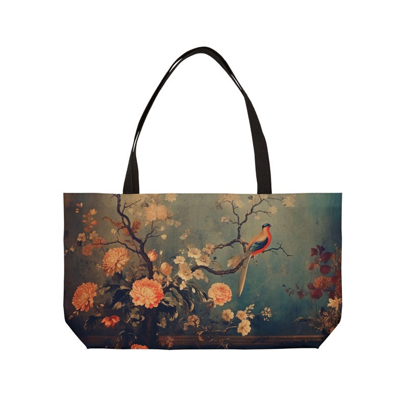 May include: A tote bag with a floral and bird design. The bag features a teal background with orange flowers, a bird perched on a branch, and black handles. The design has a vintage aesthetic.