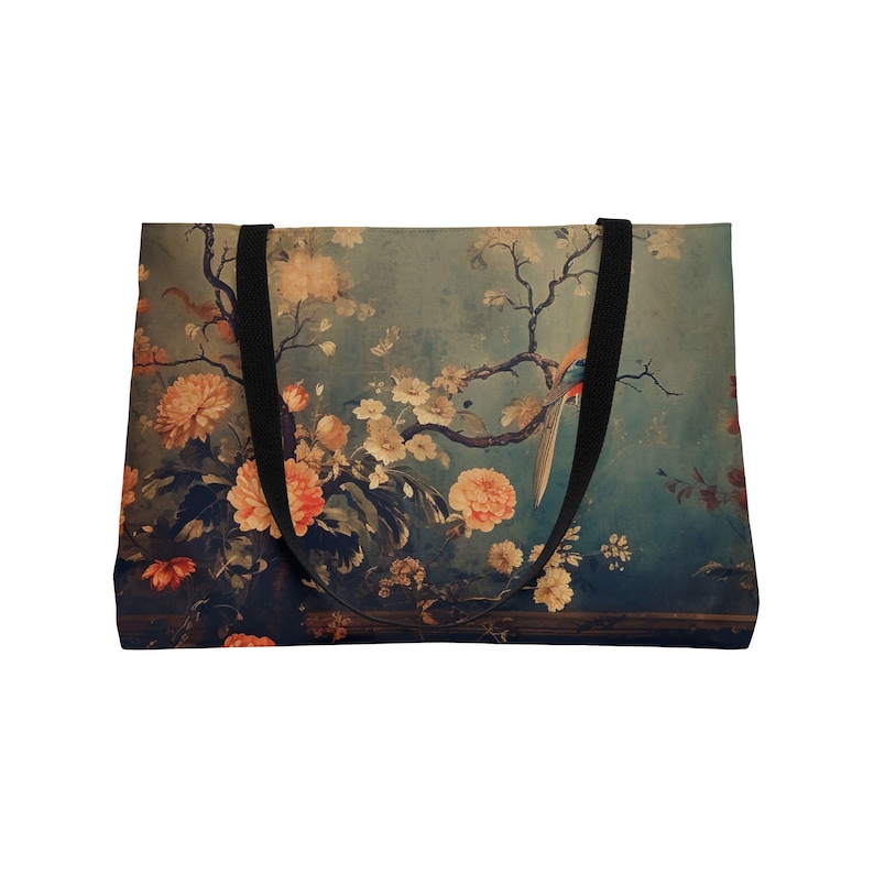 May include: A rectangular tote bag featuring a vintage floral design with peach and white flowers, a bird, and black handles. The background is a muted teal color, creating a classic, artistic aesthetic. The bag is designed for carrying items.