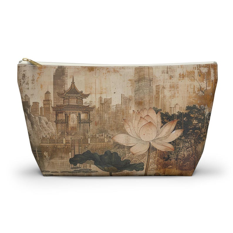 May include: A beige zippered pouch featuring a vintage-style illustration of a pagoda, lotus flower, and cityscape. The artwork is in shades of brown and tan, with a gold zipper. The pouch is designed for cosmetics or small items.