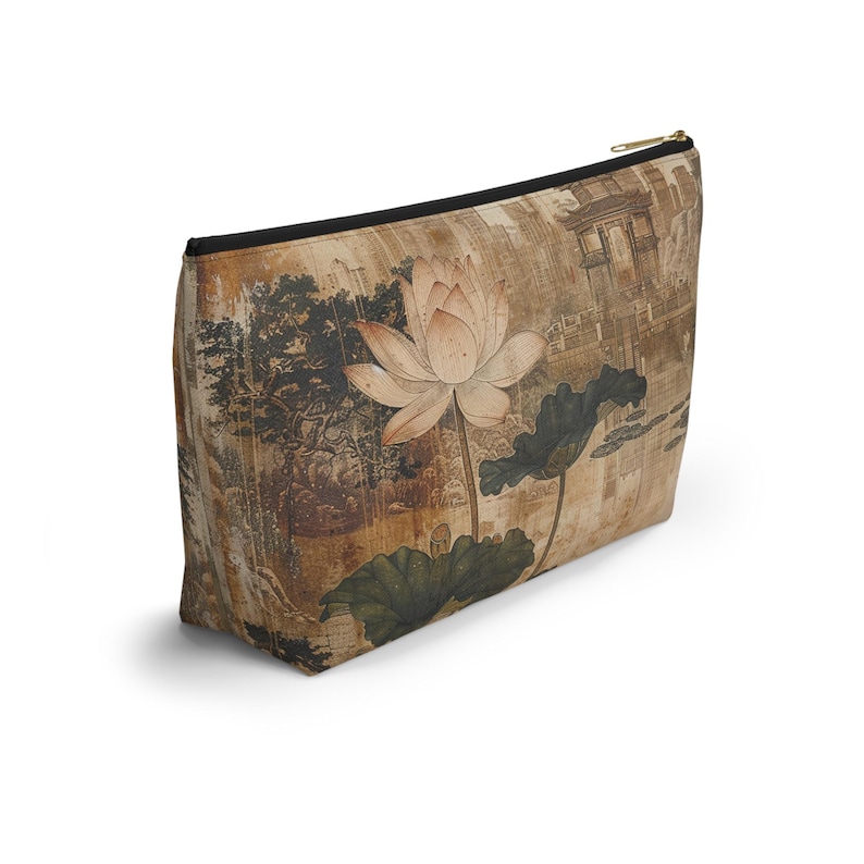 May include: A rectangular cosmetic bag with a zipper closure. The bag features a vintage-style illustration of a lotus flower, leaves, and a landscape scene in shades of brown, beige, and green.