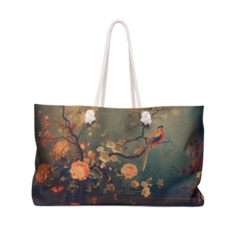 May include: Large tote bag with a vintage-style floral and bird design. The bag features a teal background with orange flowers and a colorful bird perched on a branch. It has white rope handles.