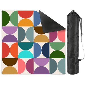Pu&ograve; includere: Una coperta da picnic quadrata con un motivo geometrico ripetuto di semicerchi multicolori nelle tonalit&agrave; del rosso, arancione, giallo, verde, blu, viola e marrone su sfondo crema, con un lato inferiore nero e una borsa nera per il trasporto.