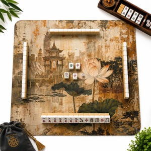 May include: A square mahjong mat featuring a sepia-toned illustration of a traditional pagoda and a large lotus flower. The mat is arranged with white mahjong tiles in rows, a wooden tile rack, a small die, and a black drawstring storage bag.