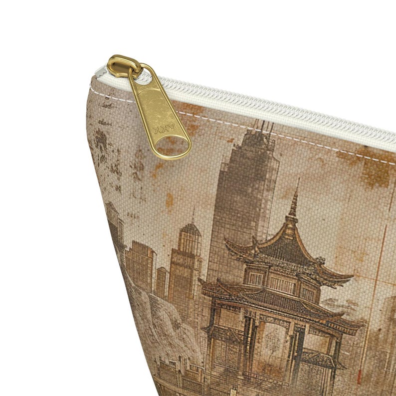 May include: A beige zippered pouch featuring a vintage-style illustration of a pagoda and city skyline. The pouch has a gold-colored zipper pull with the brand name "ZOKY" embossed on it. The design is printed on a textured fabric.