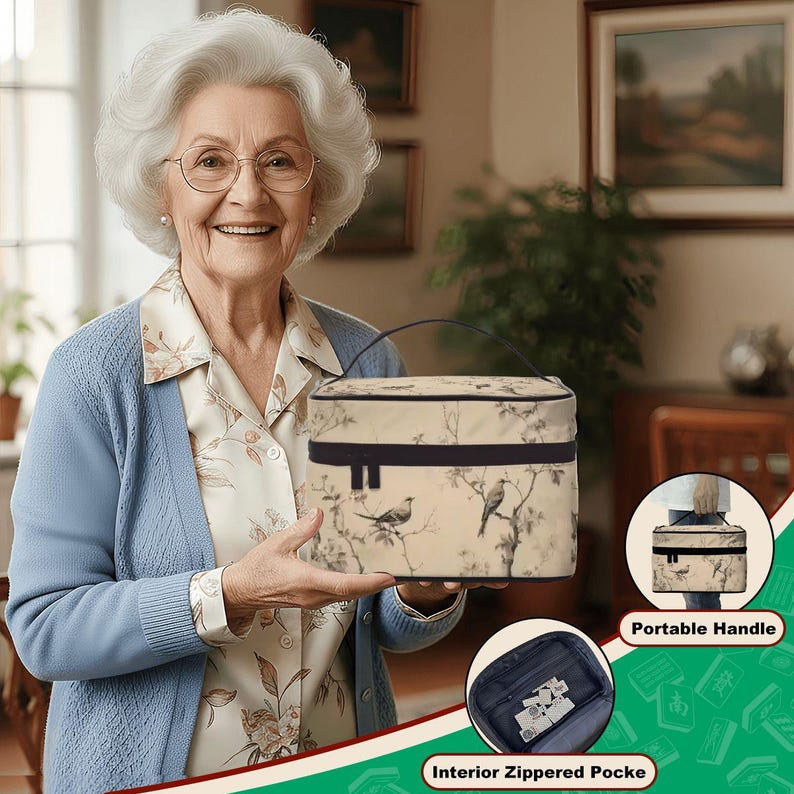 Op de afbeelding: Een beige make-uptas met een zwarte handgreep en rand, met een vogel- en takkenontwerp. De tas heeft een vak met ritssluiting en een draagbare handgreep. De tas wordt door een persoon vastgehouden.