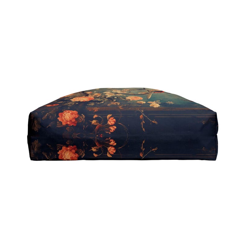 May include: A dark blue tote bag with a floral design featuring orange and peach-colored roses and other flowers. The bag has a rectangular shape and a soft, fabric-like texture. The floral pattern is set against a dark background.