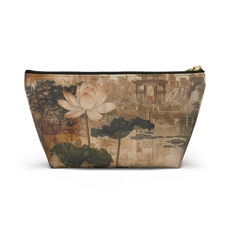 May include: A beige cosmetic bag featuring a vintage-style illustration of a lotus flower, lily pads, and a traditional Asian landscape. The bag has a black zipper and a gold-colored zipper pull.
