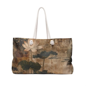 May include: Large tote bag featuring a vintage-style illustration of a lotus flower and leaves. The bag has a cream-colored rope handle and a rectangular shape. The artwork is in muted tones of brown, beige, and green.