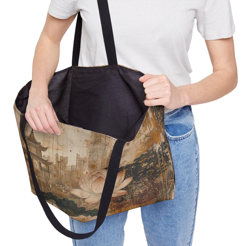 May include: Large tote bag with a vintage-style Asian-inspired design. The bag features a cityscape with a pagoda, lotus flower, and trees in shades of brown, beige, and green. It has black straps and a black interior.