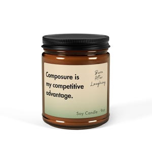 May include: A brown soy candle in a glass jar with a black lid. The label reads "Composure is my competitive advantage." and "Burn After Laughing." The candle is 9 oz.