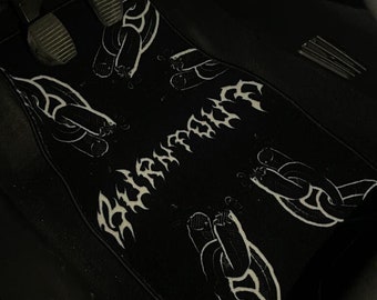 Könnte beinhalten: Schwarze Autofußmatte mit einem weißen Kettenmuster und dem Wort "BURNIN'" in gotischer Schrift.