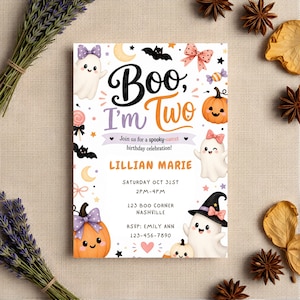 May include: A rectangular birthday invitation card featuring the text Boo, I'm Two, Lillian Marie, and event details. The design includes illustrations of white ghosts, orange pumpkins, black bats, yellow moons, pink bows, and colorful candies.