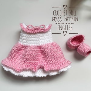 Peut inclure: Une robe de poupée en crochet rose et blanche avec un nœud blanc et des chaussures roses assorties. La robe a un volant blanc en bas et un corsage rose. Patron de robe de poupée en crochet en anglais.